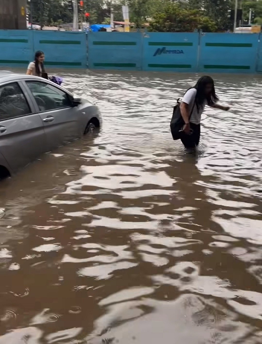 Students brave knee-deep water to reach college campus. (SVKM & NMIMS)